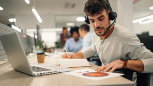 Offshore accounting professional reviewing financial reports at a laptop in an open-plan office