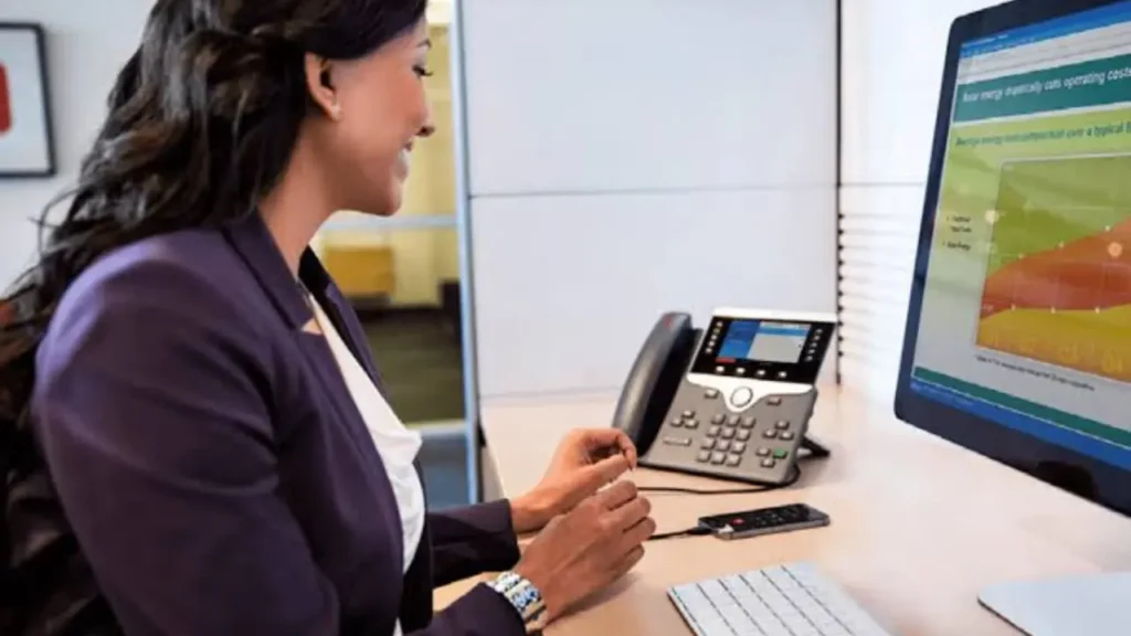 Small business owner reviewing financial charts on a desktop monitor while outsourcing bookkeeping to a remote team