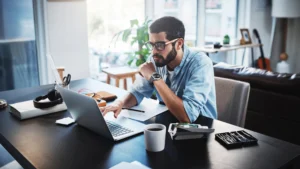 Remote professional working at a laptop in a home office, comparing nearshore and offshore outsourcing models